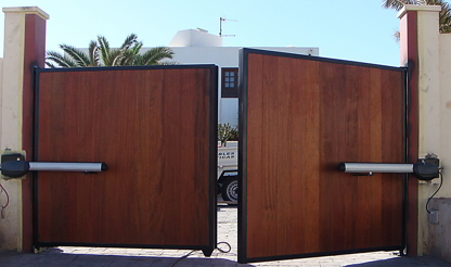 puertas abatibles de madera, semiabiertas, vistas desde el interior de un acceso residencial